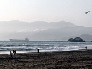Kite flyers frame freighter leaving San Francisco Bay
